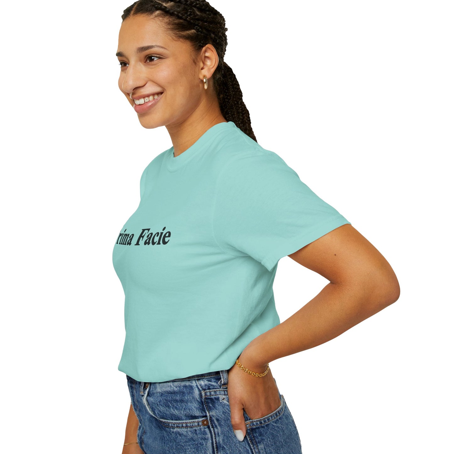Side profile of a young female model wearing a mint Prima Facie graphic T-shirt styled with blue jeans against a clean studio background.