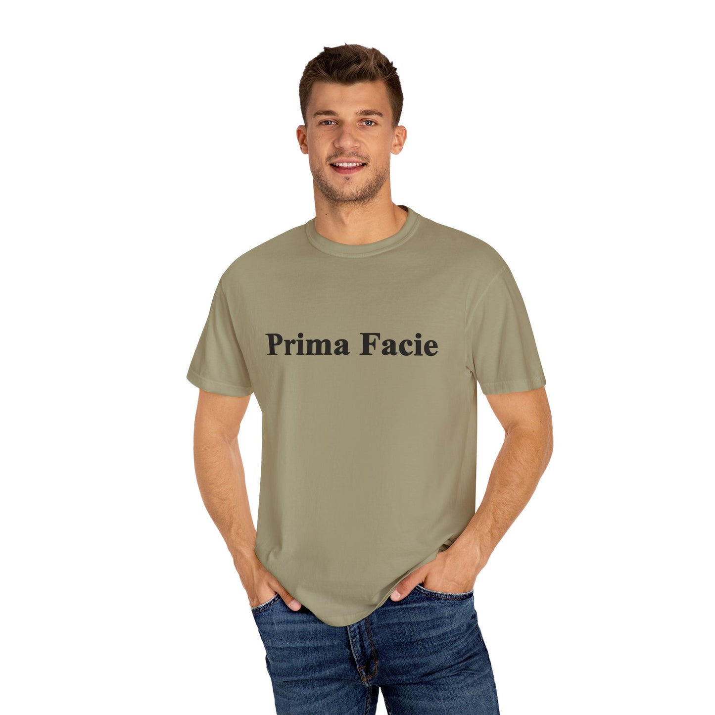 Young male model wearing an olive green Prima Facie unisex graphic T-shirt in a casual studio portrait.