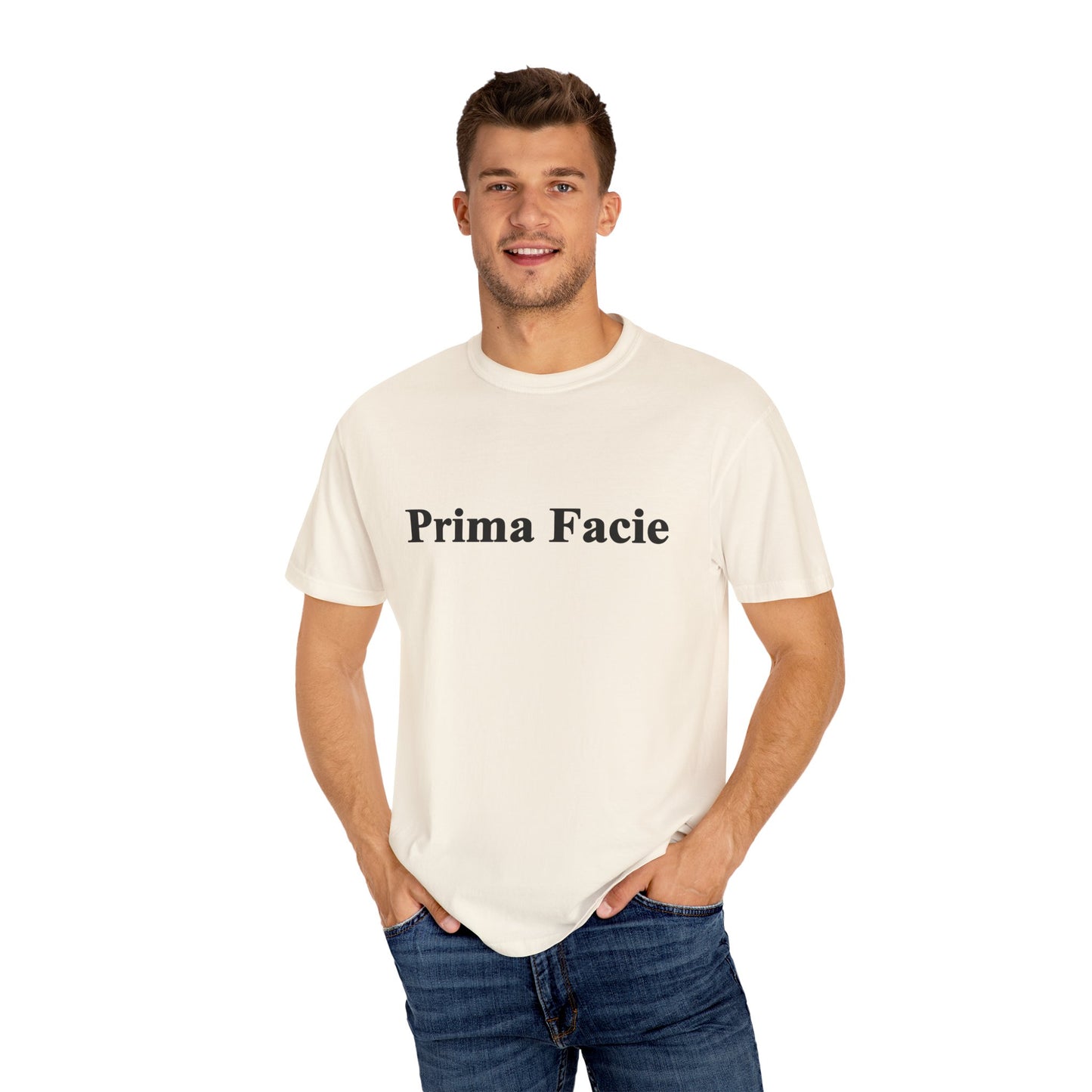 Young male model wearing a white Prima Facie unisex graphic T-shirt in a bright studio portrait.