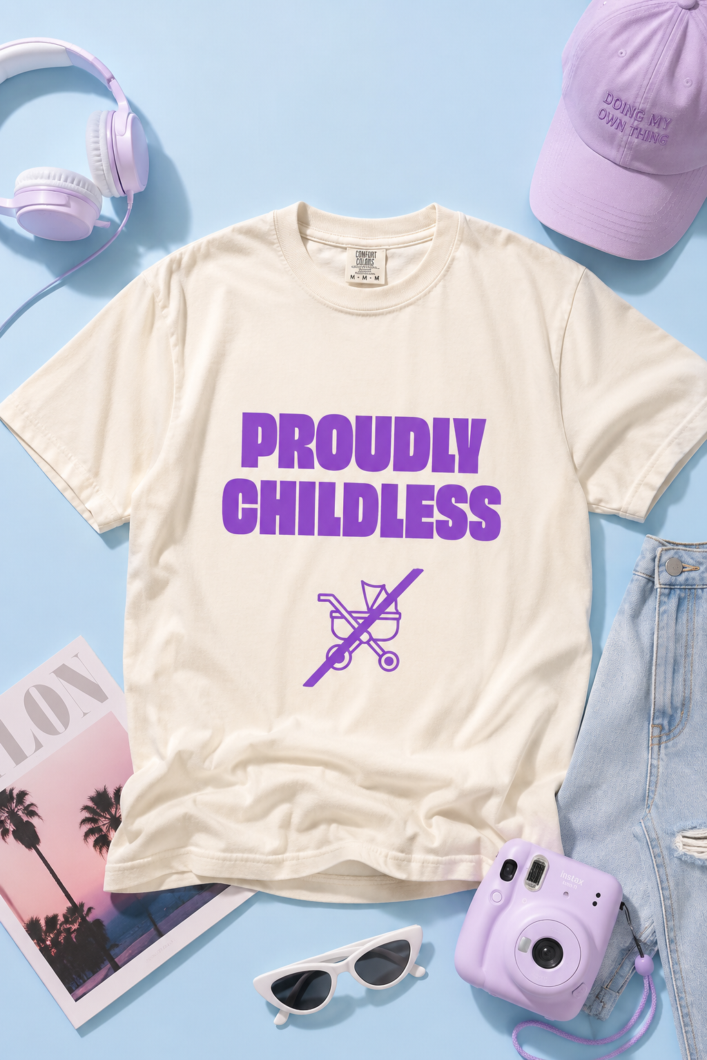 Cream Proudly Childless graphic T-shirt styled with headphones, sunglasses, denim and a camera