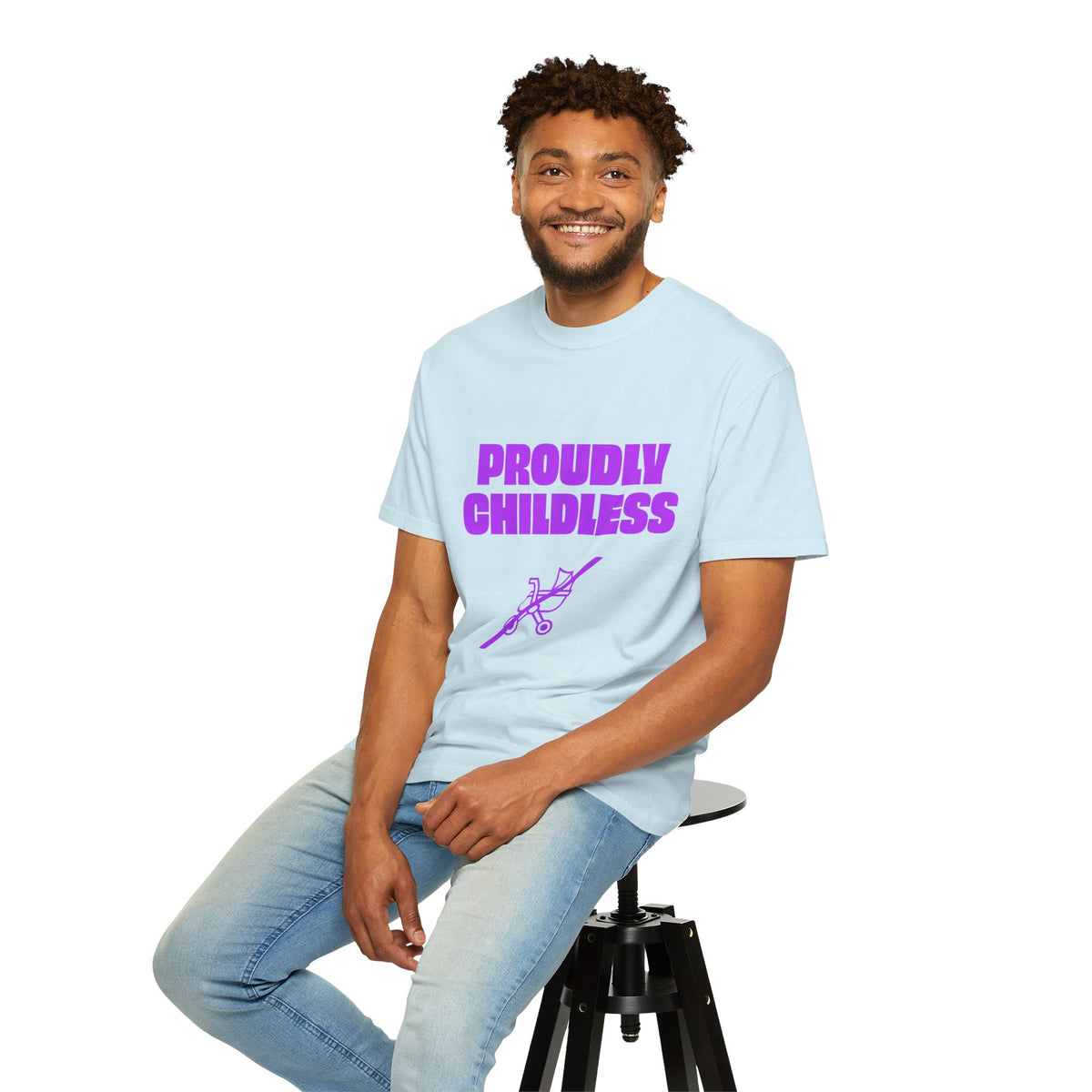 Male model wearing a light blue Proudly Childless graphic T-shirt while seated casually