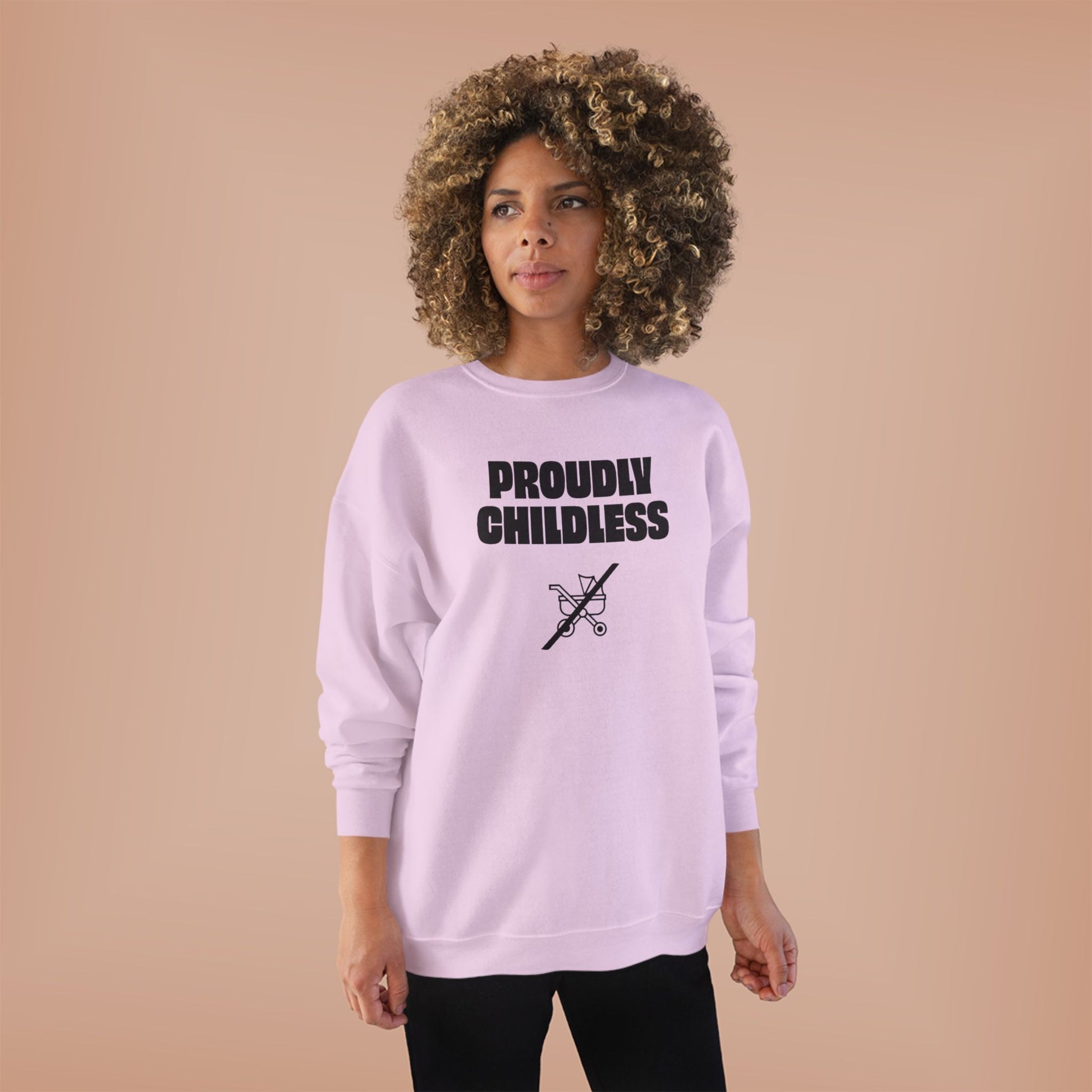Woman wearing the soft light pink Proudly Childless Sweatshirt in a relaxed studio lifestyle image.