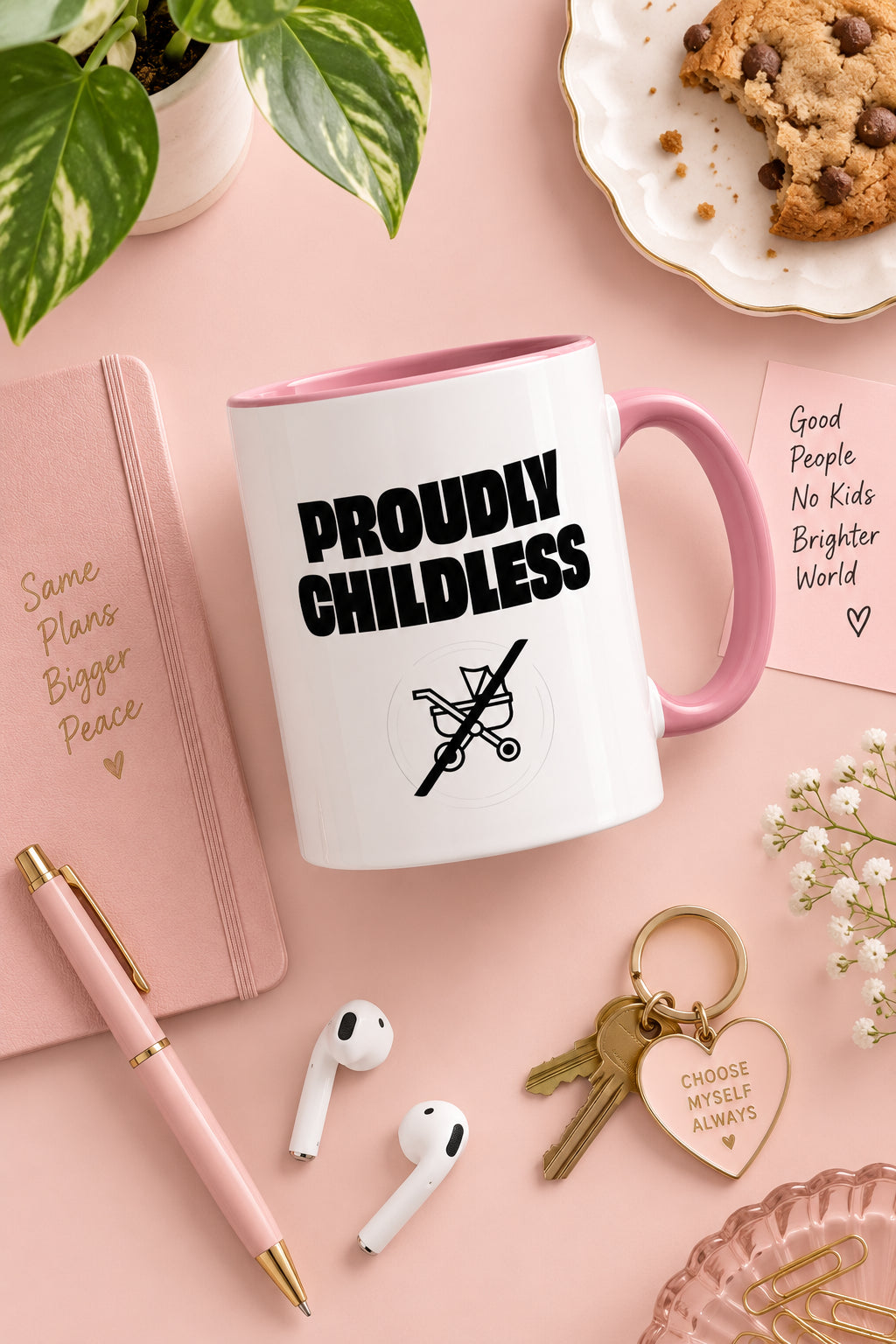 Pink Proudly Childless Mug in a pastel flat lay with stationery, plant and everyday accessories