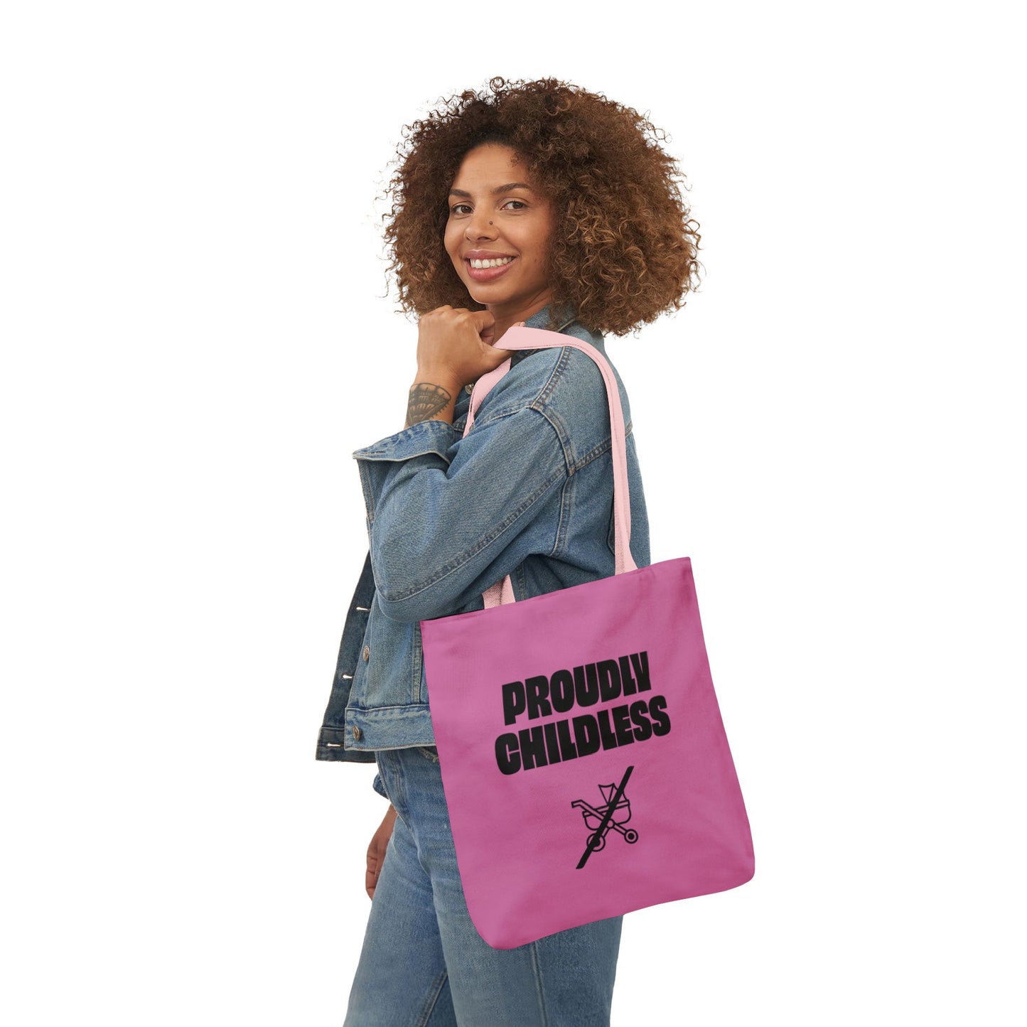 Woman wearing denim and carrying a pink Proudly Childless statement tote bag
