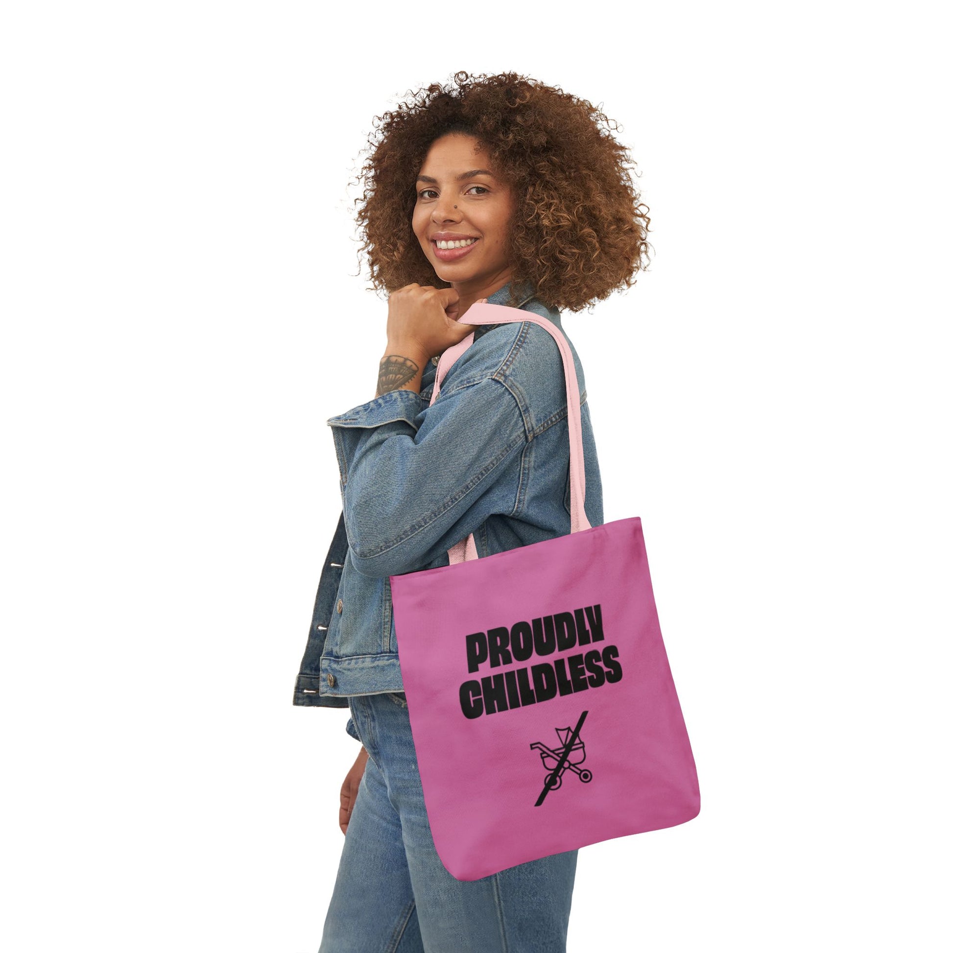 Woman wearing denim and carrying a pink Proudly Childless statement tote bag
