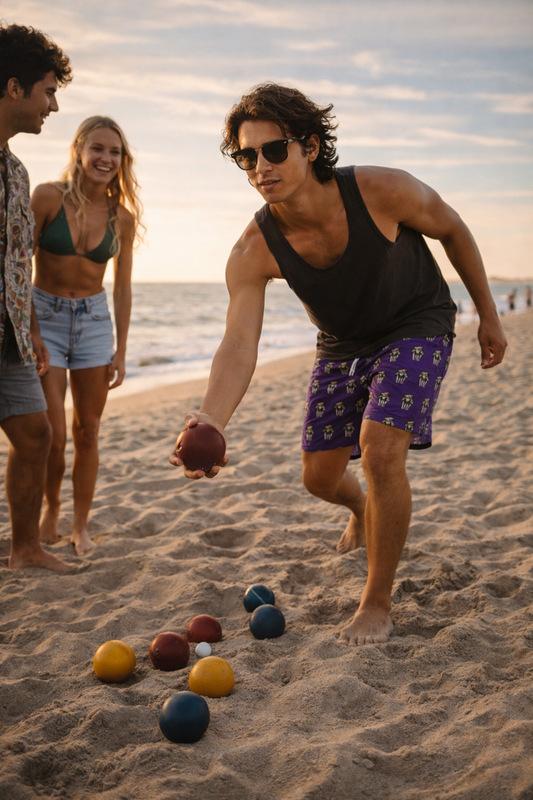 Man playing beach game wearing purple 8-bit zebra arcade swim shorts with friends at sunset