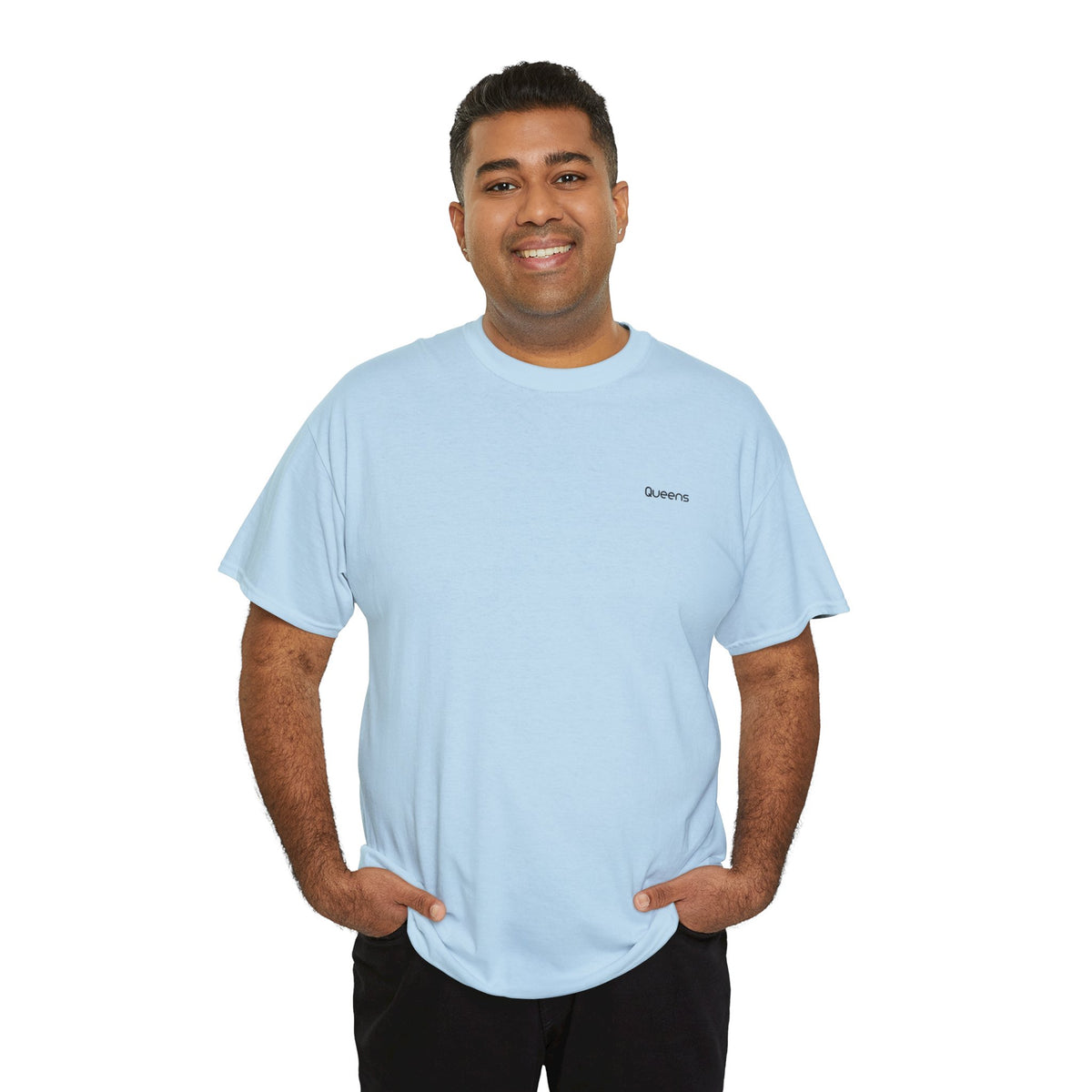 Man modeling a light blue Queens T-shirt with small black chest lettering and dark trousers.