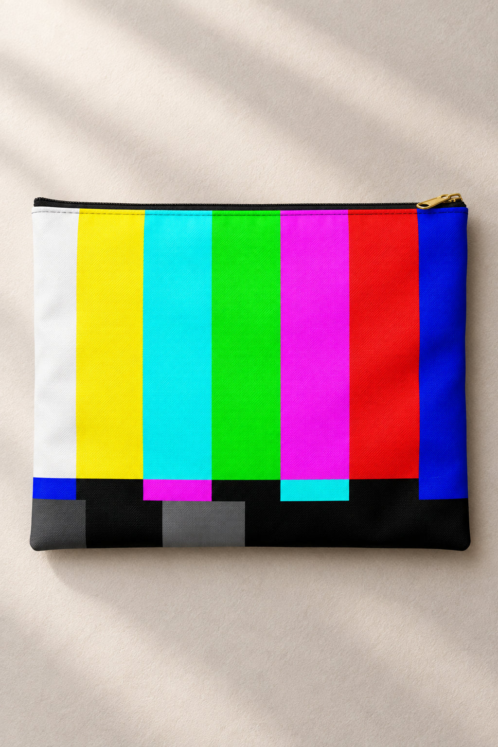 Retro TV color bars accessory pouch with a black zipper and vibrant broadcast test pattern on a soft neutral background.
