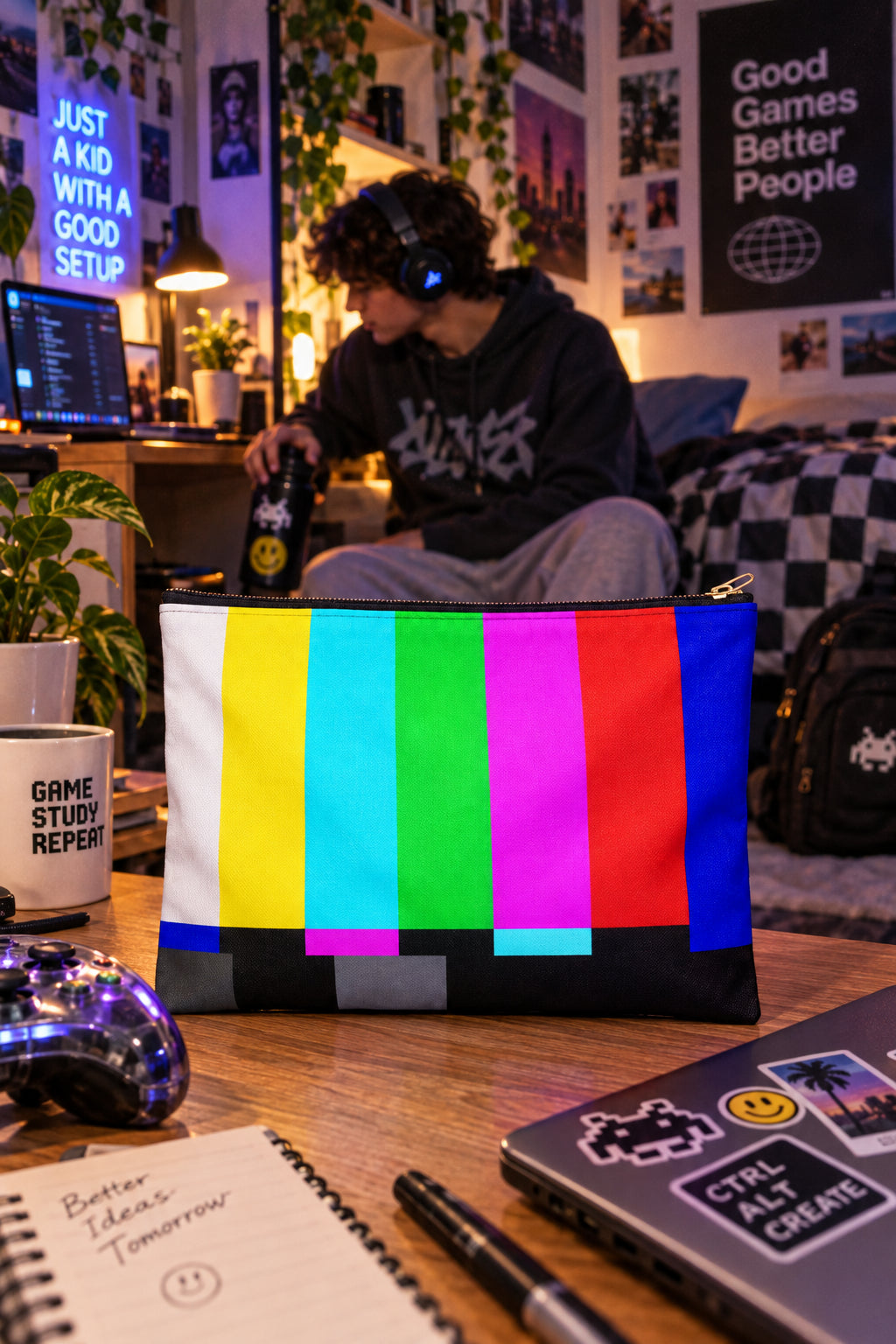 Retro TV color bars zipper pouch on a desk in a Gen Z college dorm with a gaming setup and warm ambient lighting.