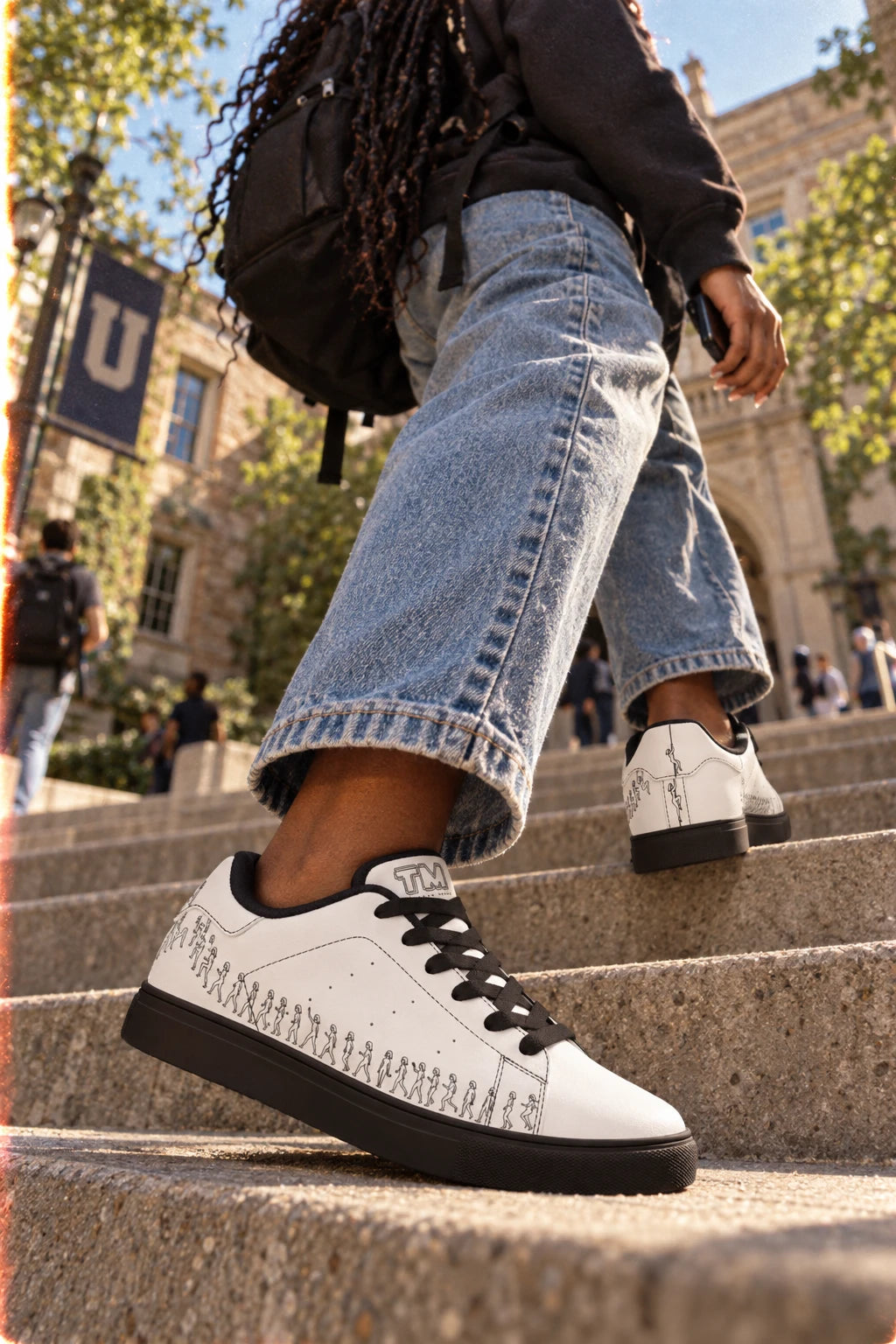 Woman wearing Running Out white leather sneakers with black sole on college campus steps