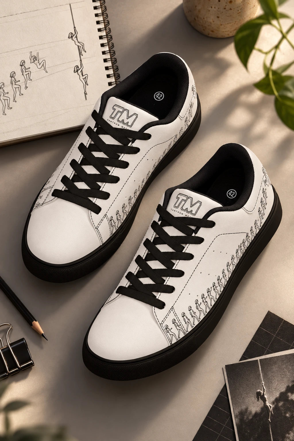 Running Out white leather sneakers with black sole and black laces in artistic flat lay