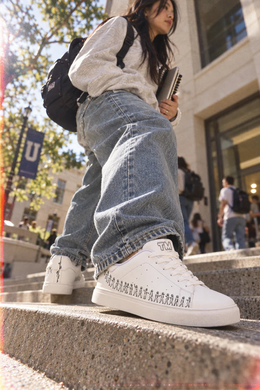 Woman wearing Running Out white leather low-top sneakers on college campus steps