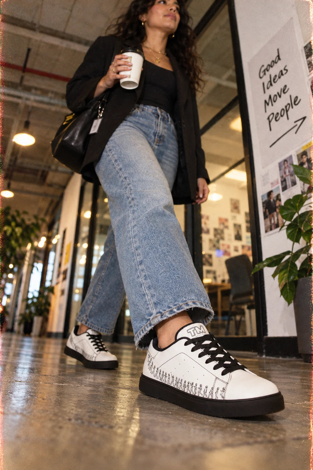 Young professional wearing Running Out white leather sneakers with black sole in an urban office