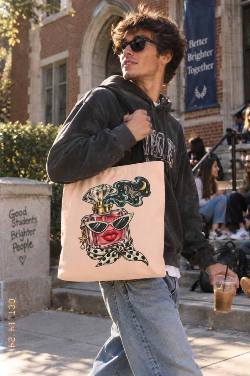 College student carrying the Scent of Chaos peach graphic tote bag with surreal perfume bottle artwork while walking through an urban campus.