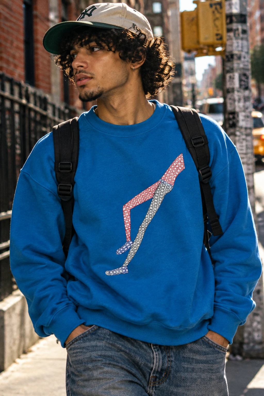 Young man wearing the blue Shapes in Shapes abstract art sweatshirt on a New York City street.