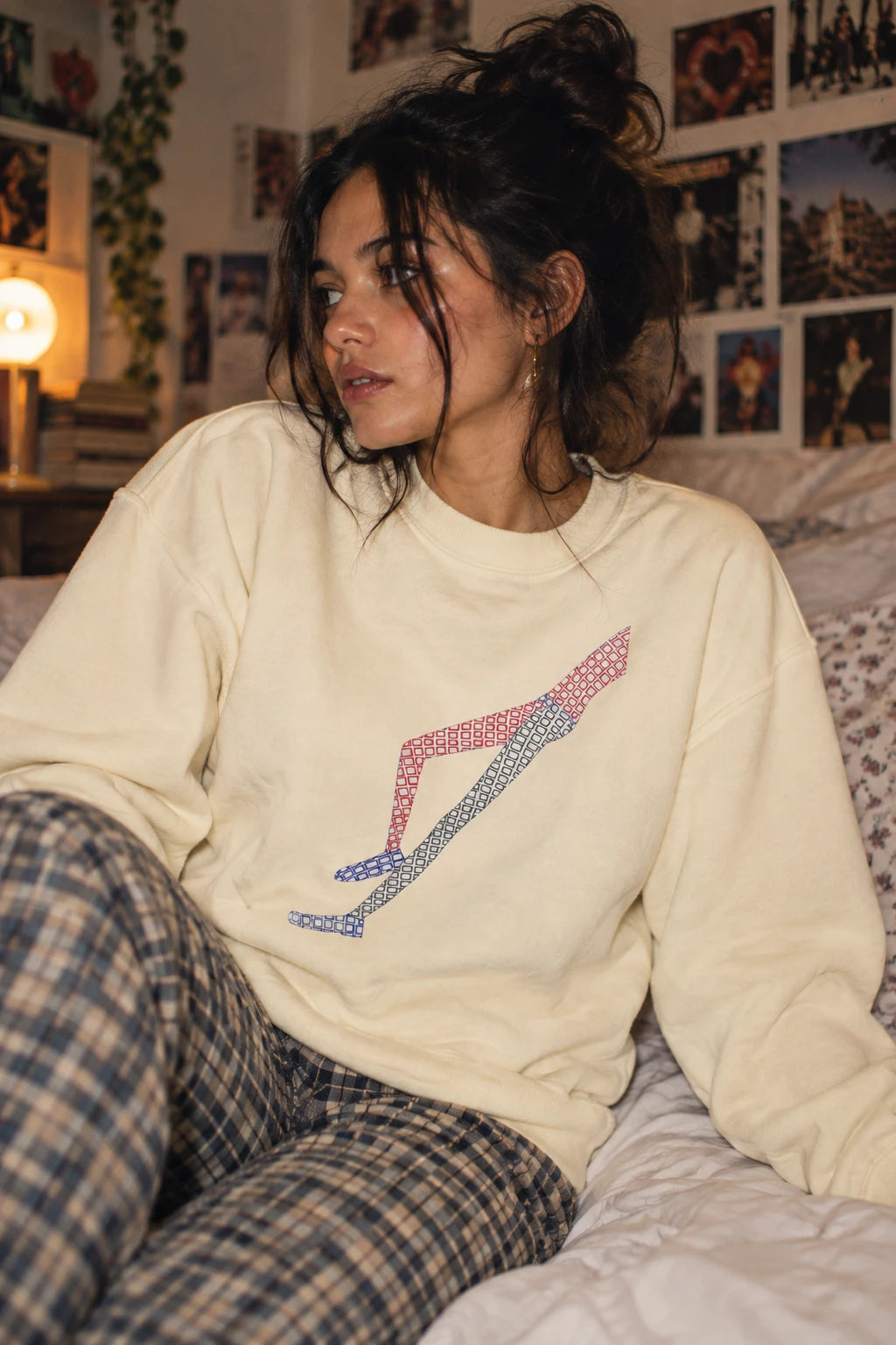 Woman wearing the cream Shapes in Shapes abstract art sweatshirt in a casual indoor lifestyle scene.