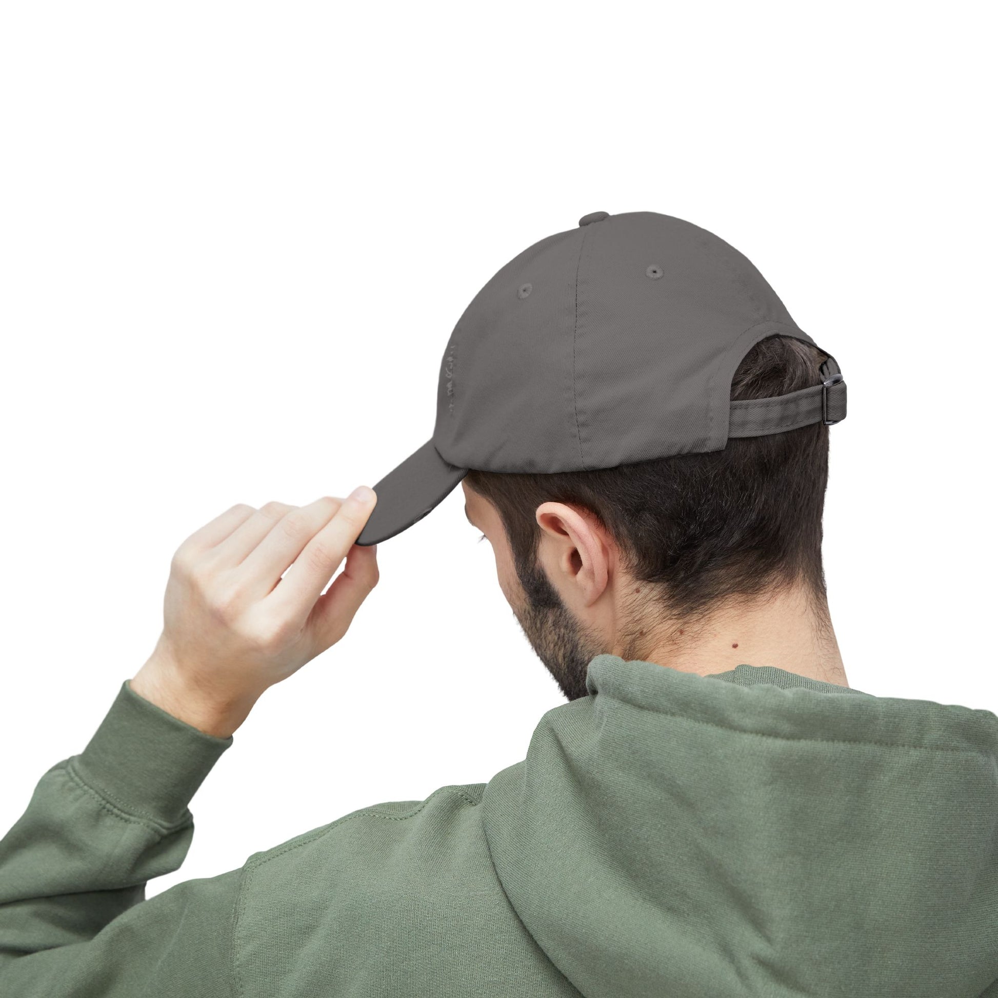 Male model adjusting Shapes in Shapes grey distressed baseball cap from the back.