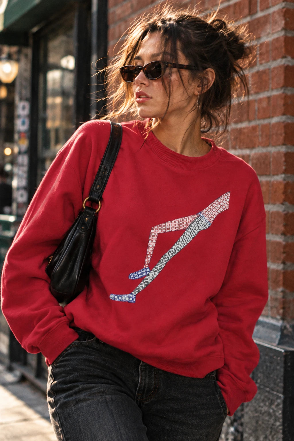 Woman wearing the red Shapes in Shapes abstract art sweatshirt in an urban streetwear