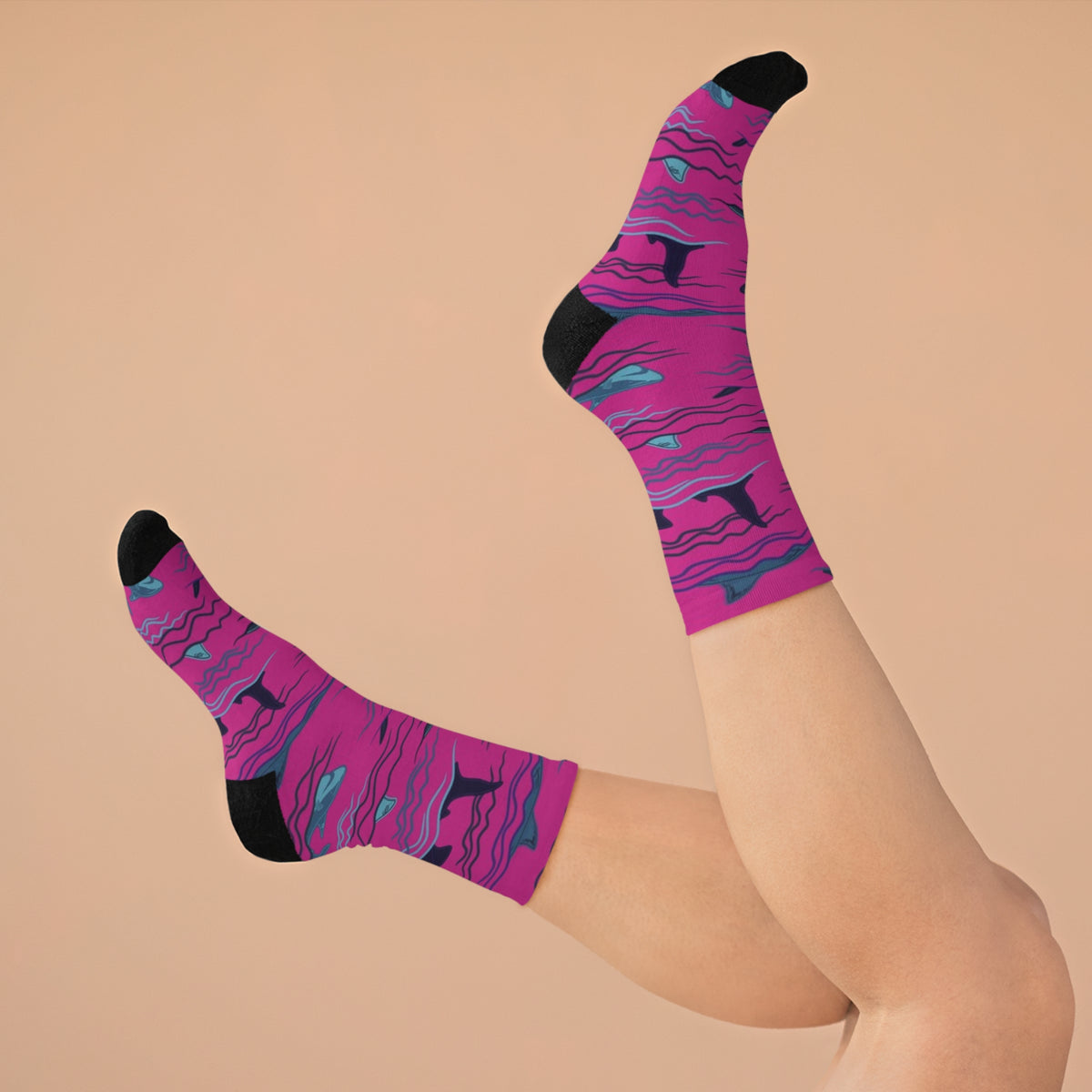 Person wearing Sharks & Friends shark print crew socks with magenta ocean pattern and black toe details.