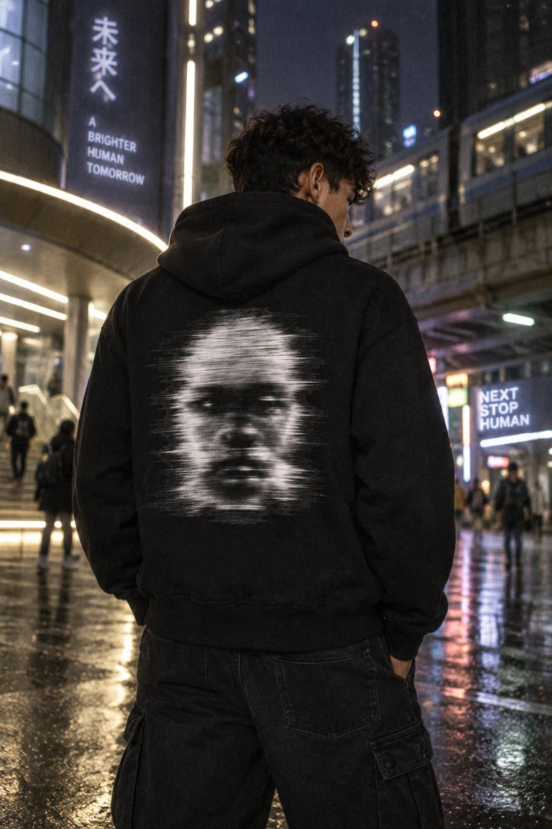 Male Gen Z wearing the Signal Ghost organic graphic hoodie in a futuristic city at night, back view lifestyle mockup