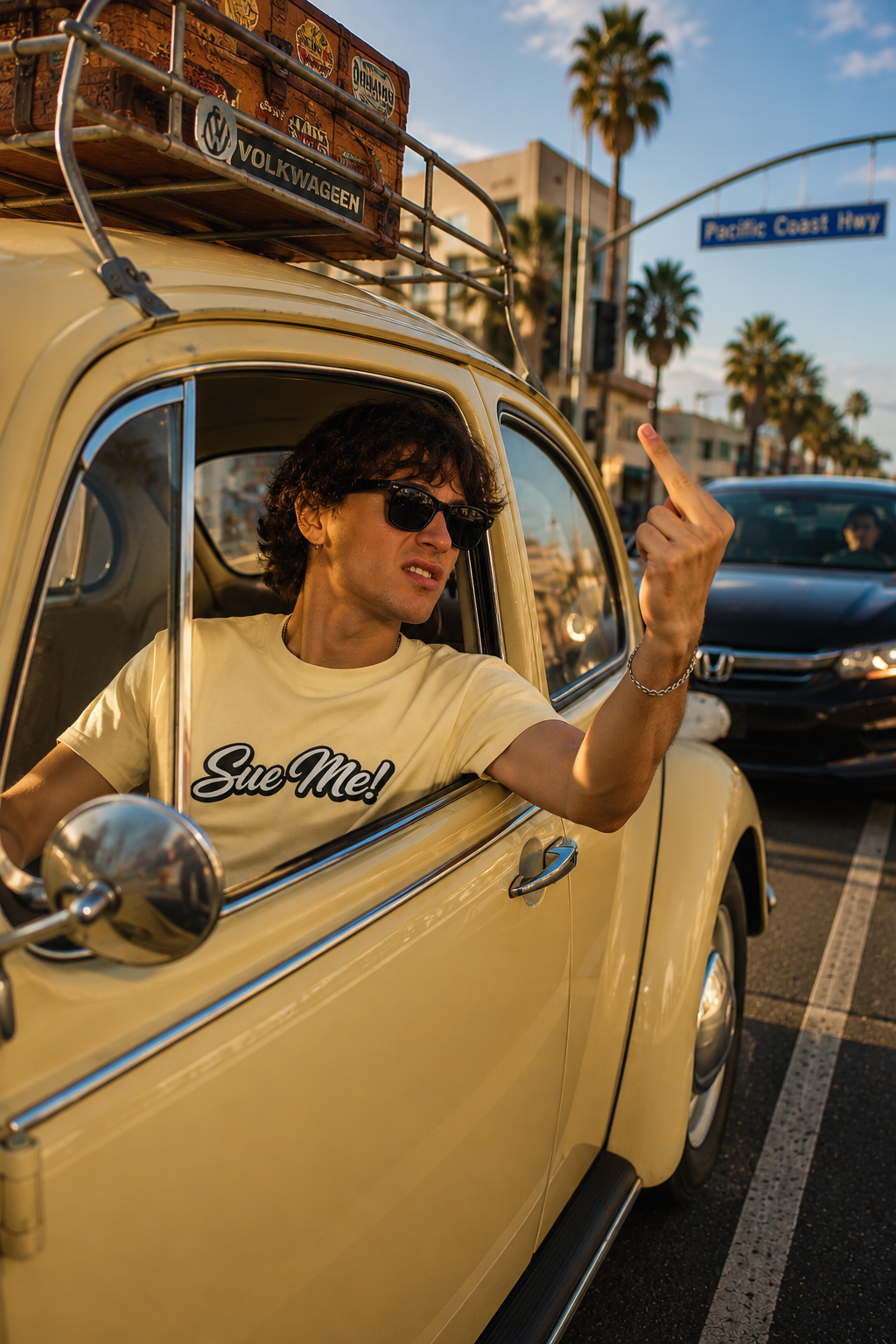 Gen Z man wearing Sue Me script graphic T-shirt while driving vintage Volkswagen Beetle