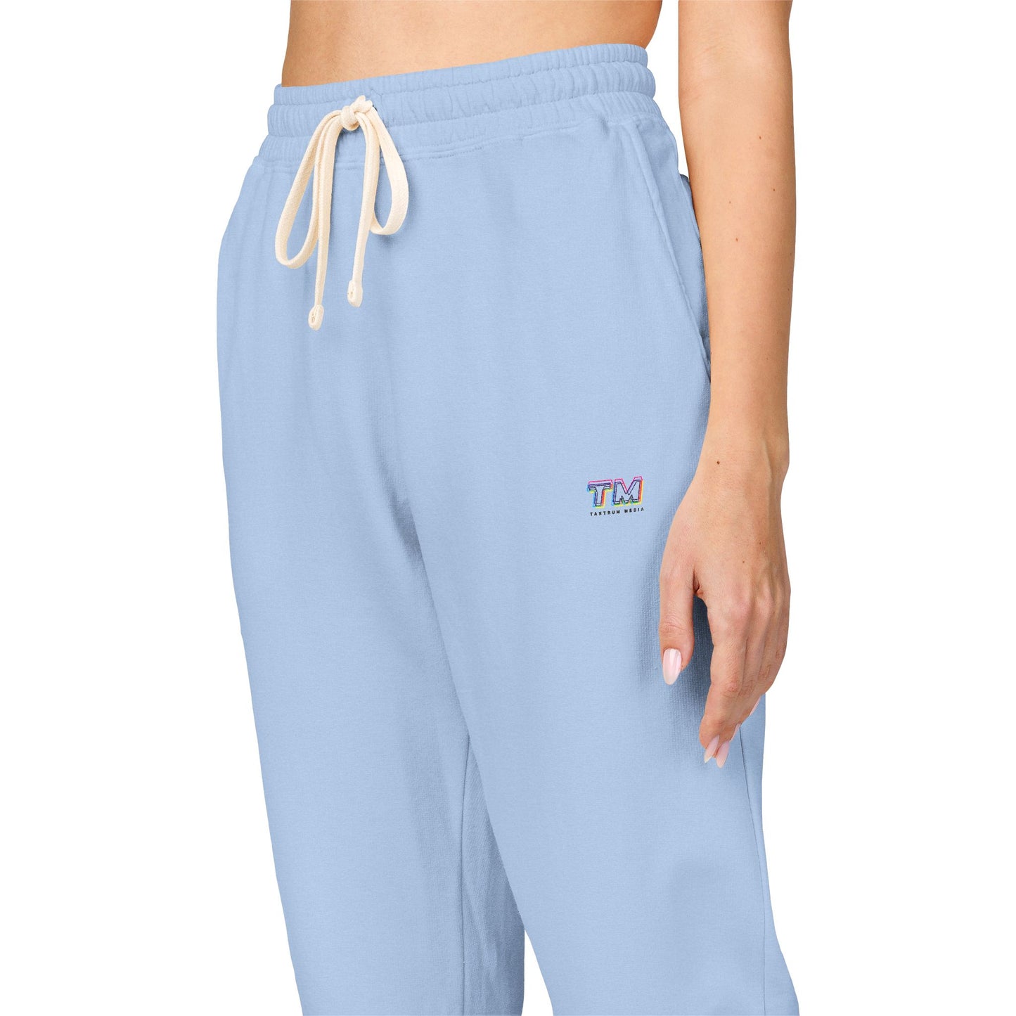 Close-up of the waistband and embroidered logo on sky blue Tantrum Media sweatpants.