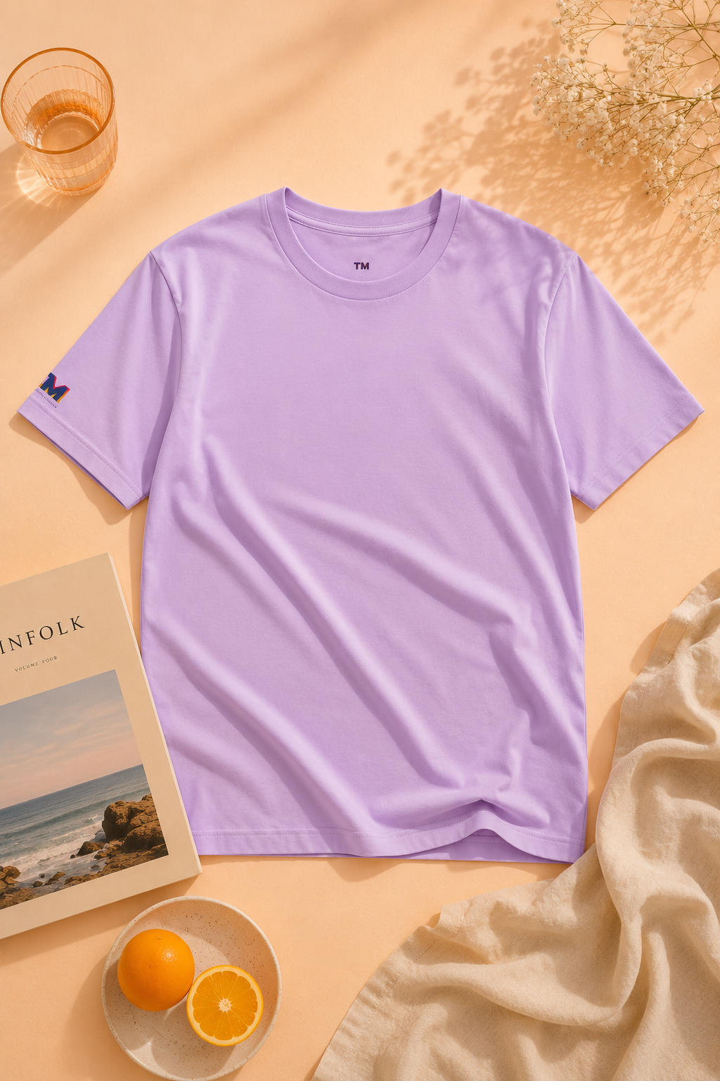 Tantrum Media Soft Tones Plain Tee in lavender flat lay on pastel orange background