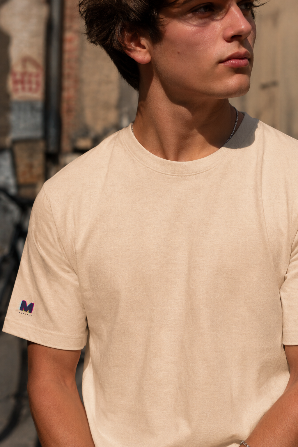 Close-up of male model wearing Tantrum Media Soft Tones Plain Tee in sand