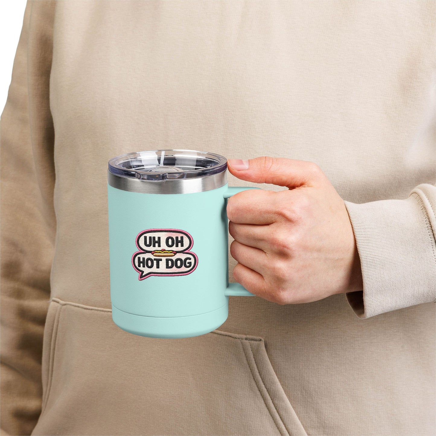 Person holding a teal Uh Oh Hot Dog MADtv insulated travel mug with clear lid