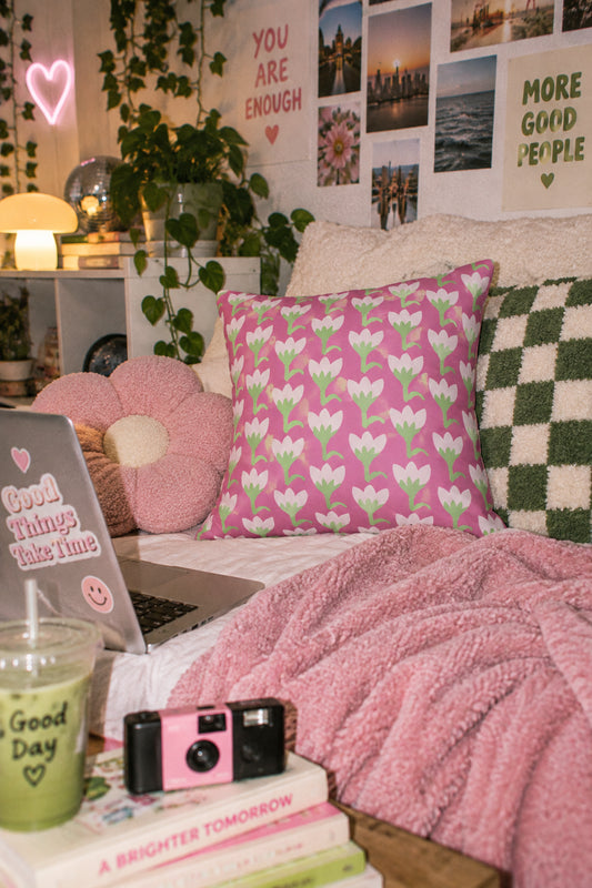Pink tulip floral throw pillow cover styled in a youthful cozy bedroom with soft pink and green decor