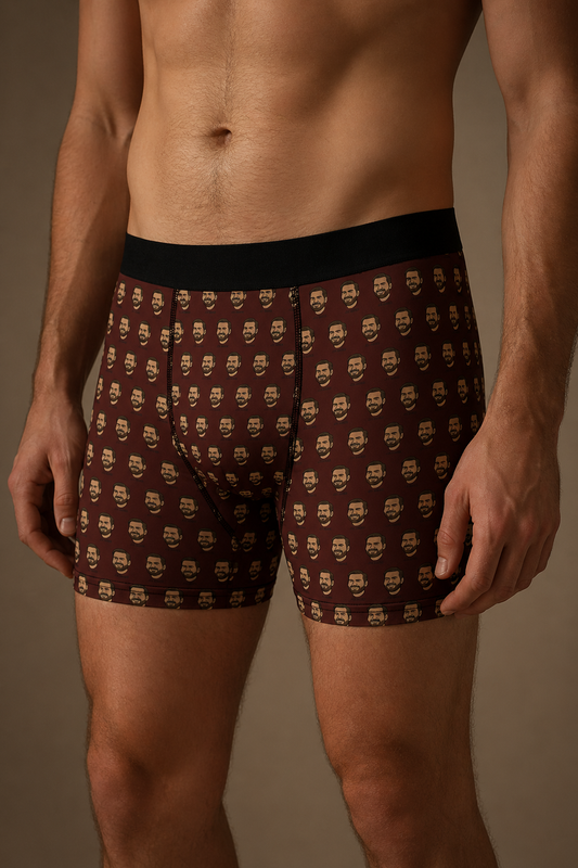 Men’s brown boxer briefs with repeating cartoon face pattern, front angled view, fitted graphic underwear from Politics Collection