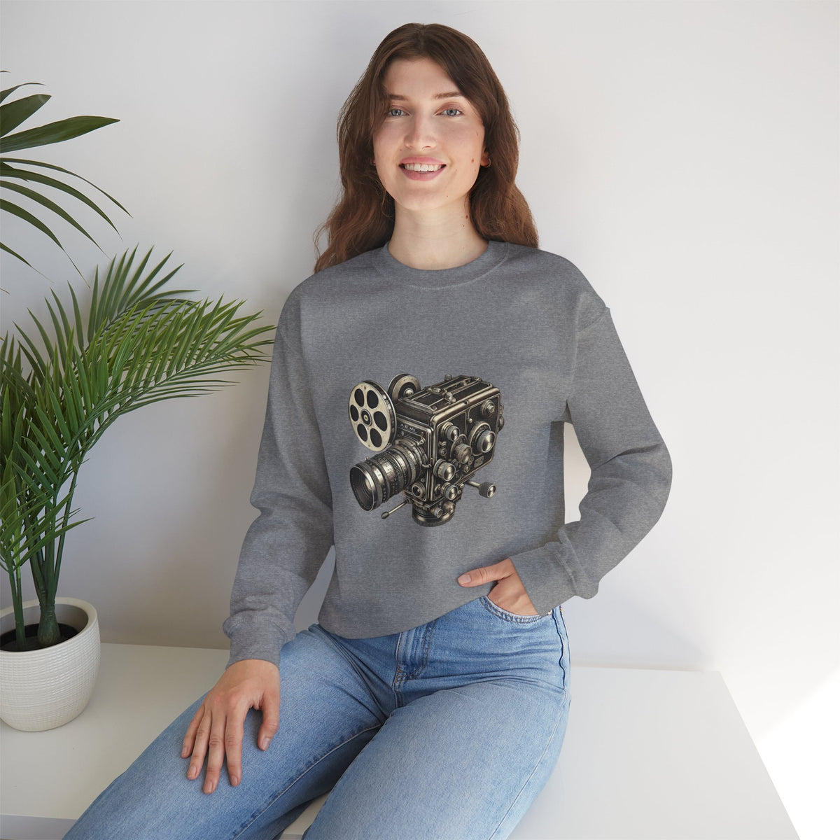 Woman seated, wearing gray Film Camera Sweatshirt, styled casually with jeans.