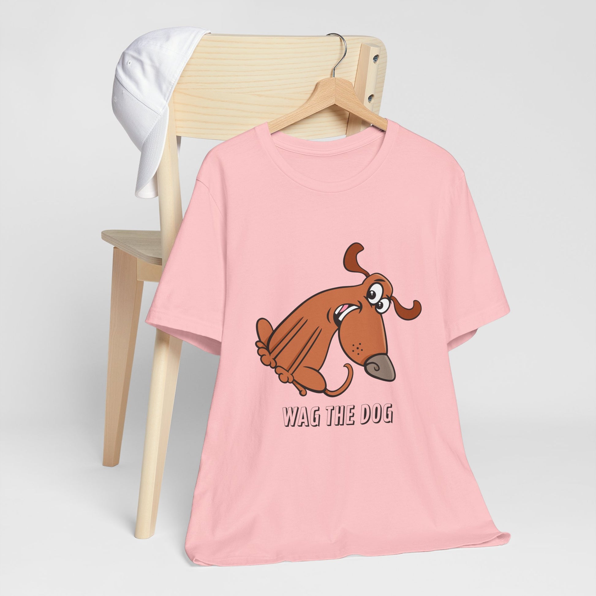 Pink Wag the Dog graphic t-shirt featuring original cartoon dog artwork inspired by the film Wag the Dog.