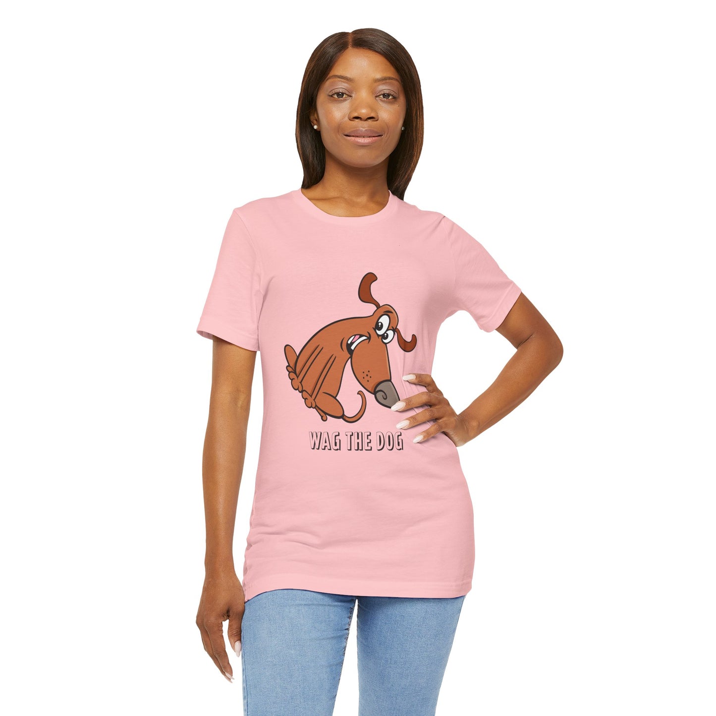 Female model wearing a pink Wag the Dog graphic t-shirt with original movie-inspired cartoon artwork.