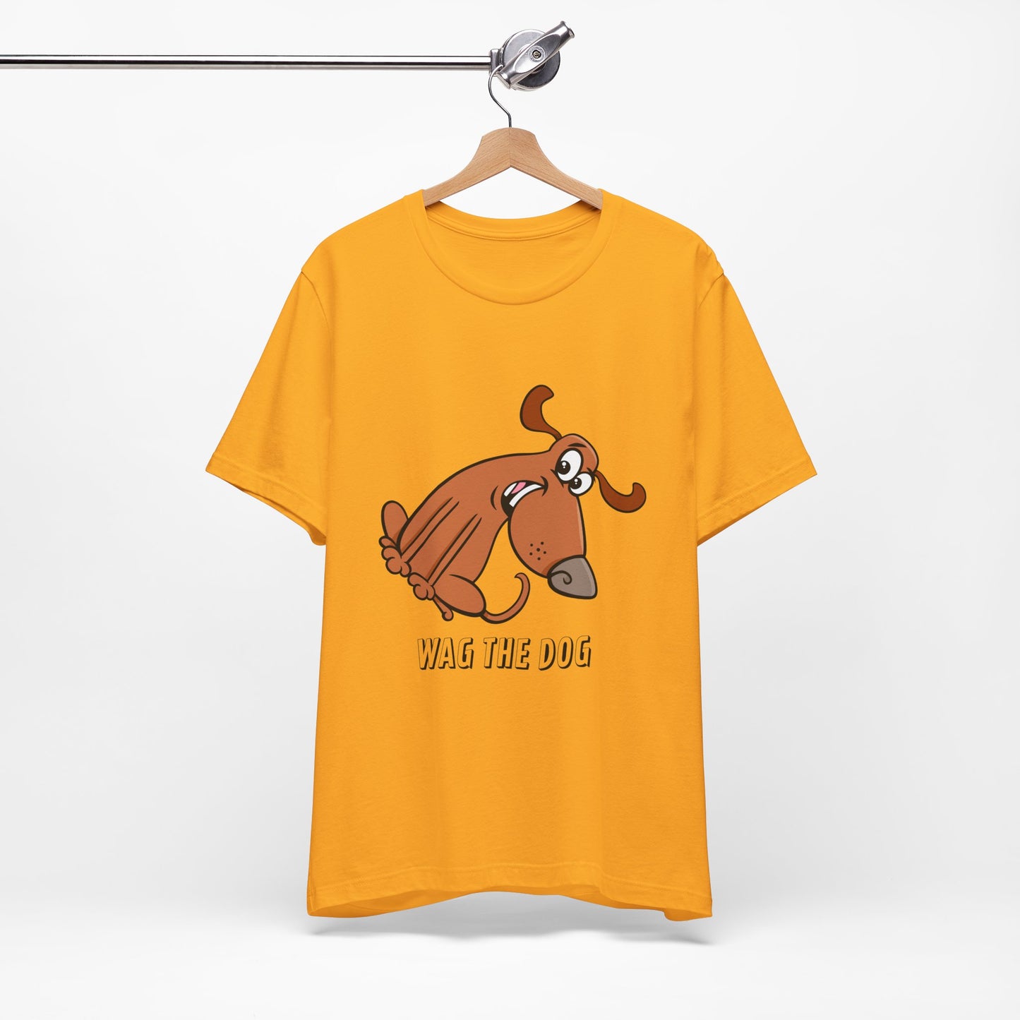 Yellow Wag the Dog graphic t-shirt featuring original cartoon dog artwork inspired by political satire and film culture.
