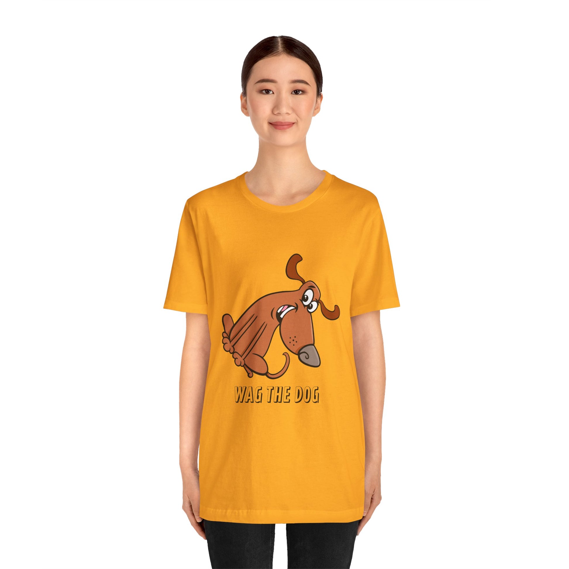 Front view of a model wearing a yellow Wag the Dog graphic t-shirt with cartoon dog illustration.
