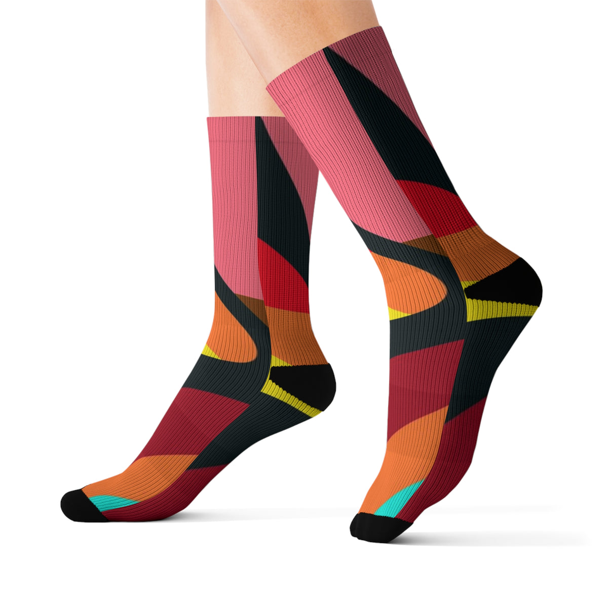 Warm color abstract crew socks worn on crossed legs with bold geometric color-block design.