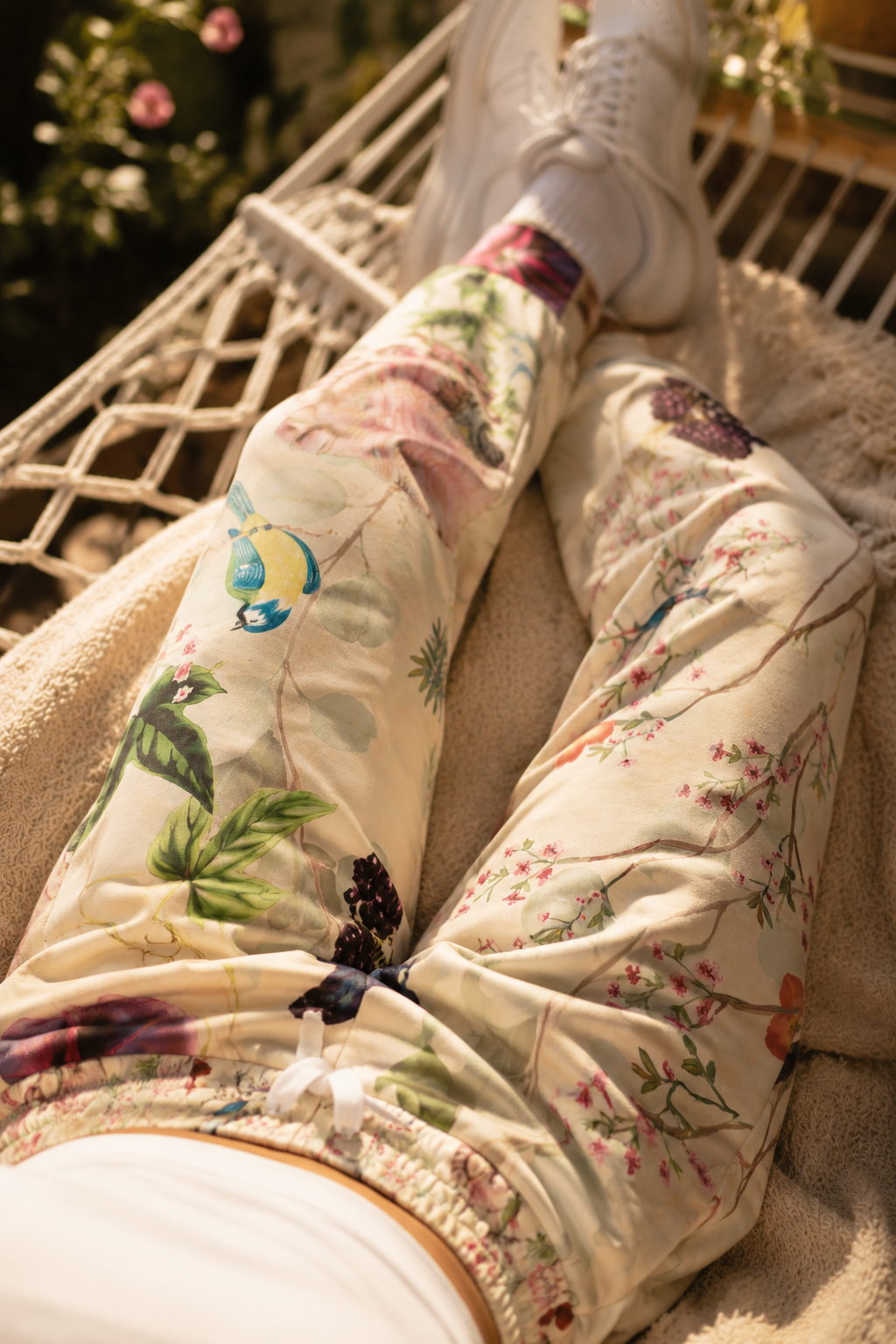 Close-up of Wildflower Meadow Joggers showcasing detailed botanical flowers, birds, and nature-inspired artwork printed on soft lightweight fabric.