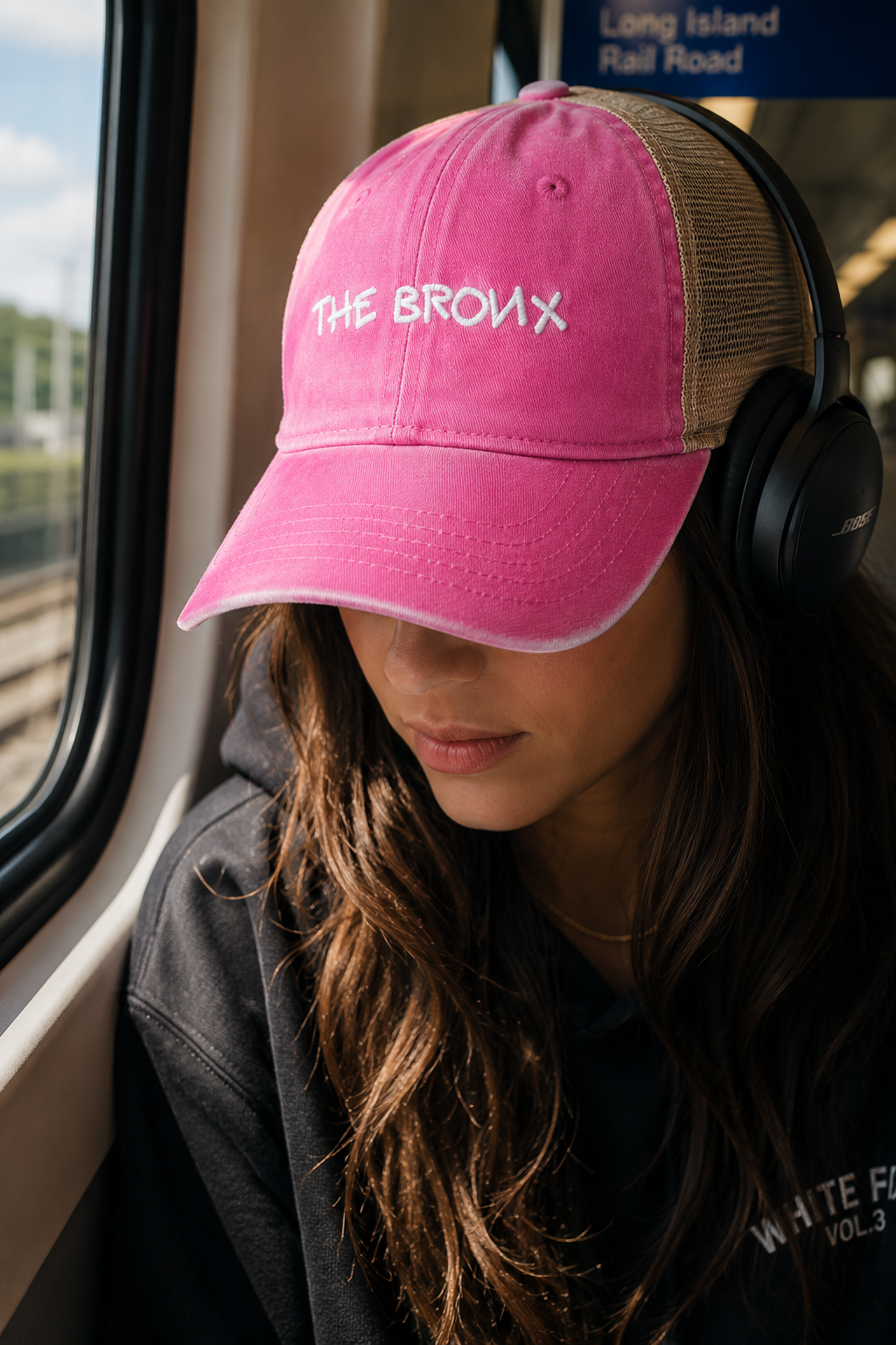 Woman wearing The Bronx hot pink trucker hat on a New York subway.