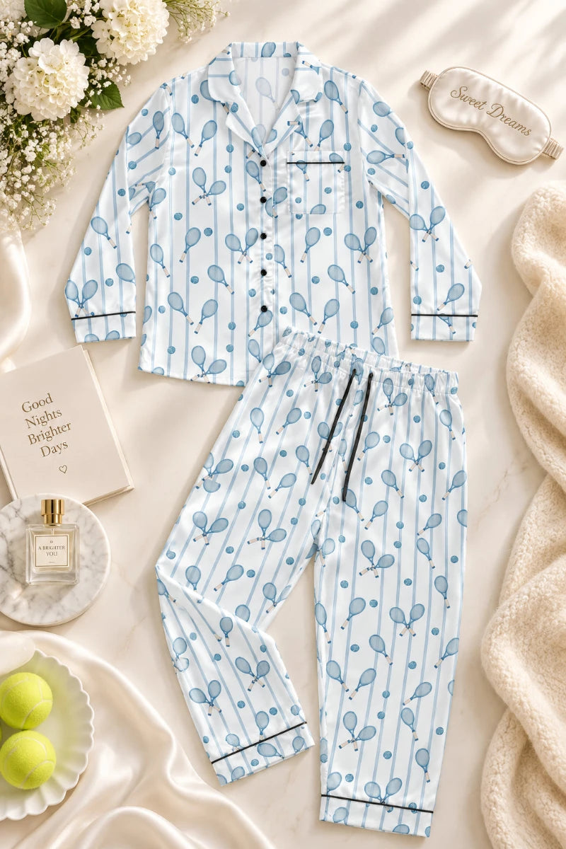Women’s tennis satin pajama set with blue racket print styled in a soft cinematic flat lay