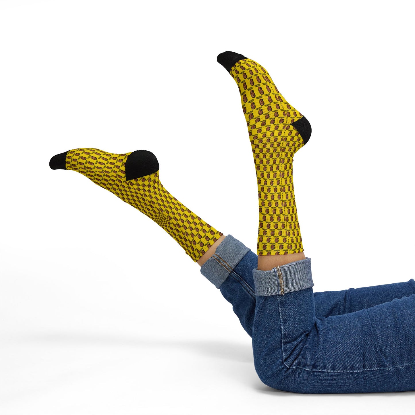 Yellow patterned socks with black toes and heels worn by a person on a white background