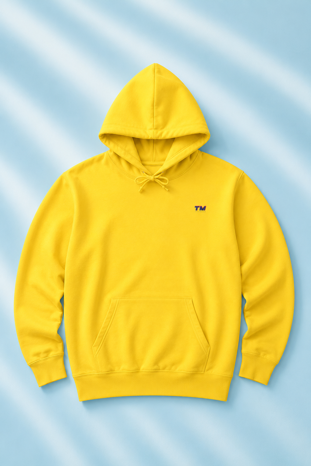 Tantrum Media EcoSmart yellow hoodie flat lay on a soft pastel blue background.