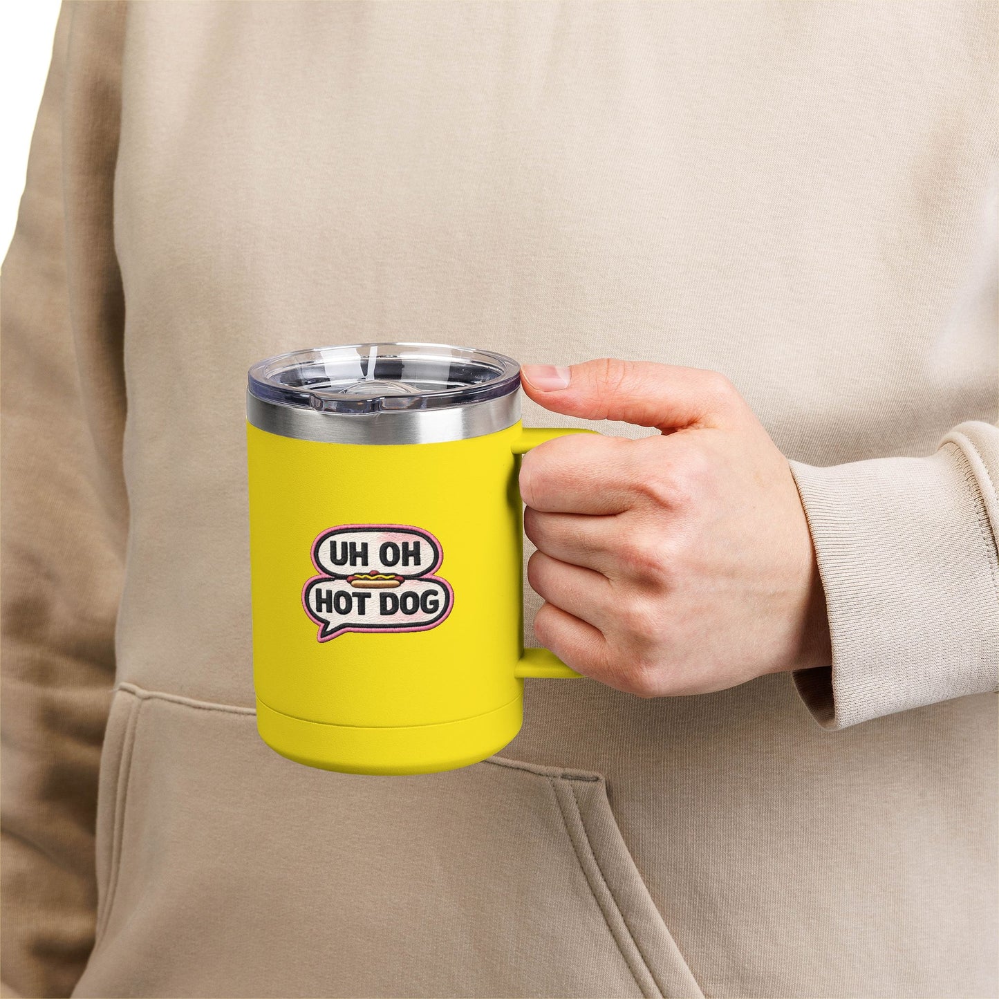 Person holding a yellow Uh Oh Hot Dog MADtv insulated travel mug with clear lid