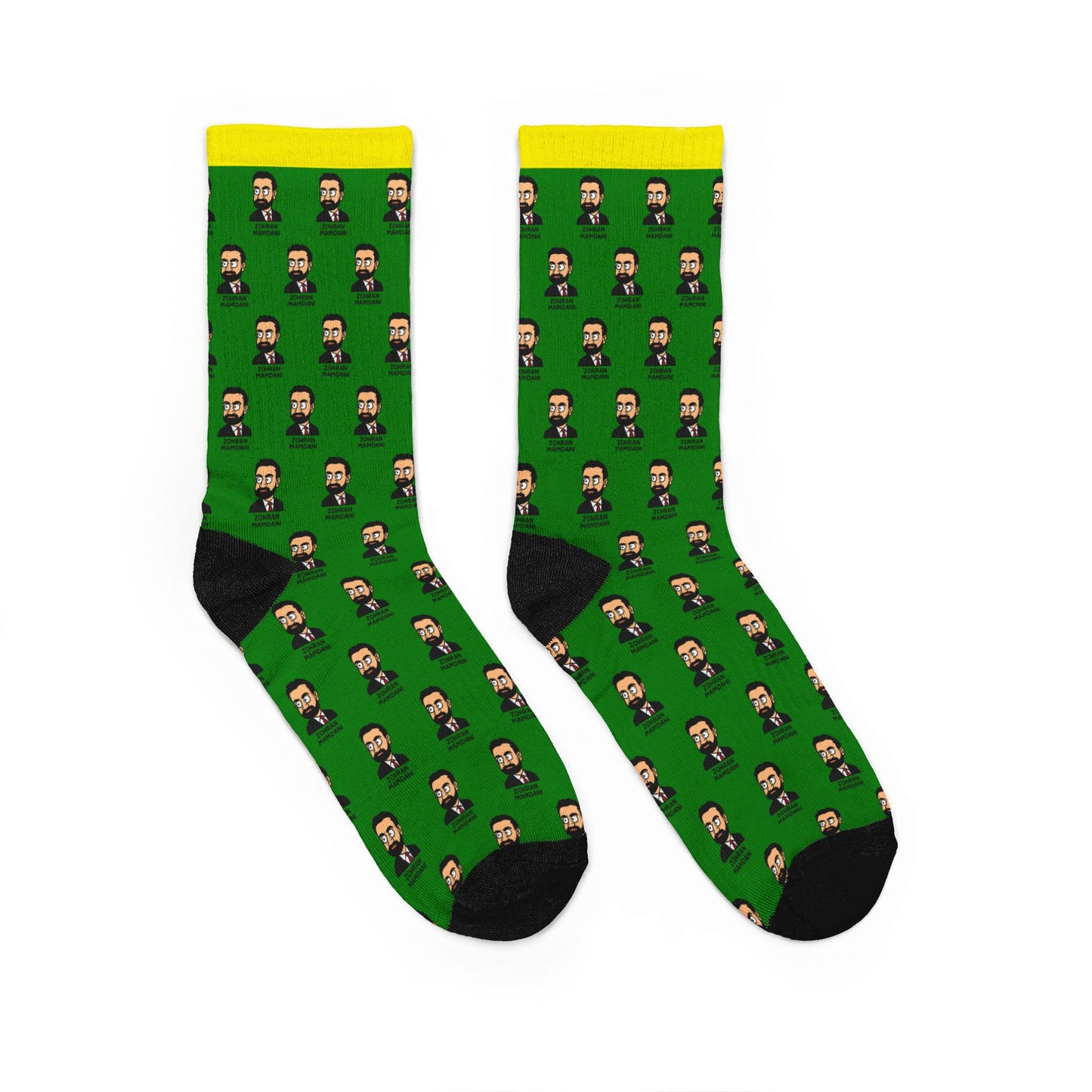 Pair of Zohran Mamdani unisex padded crew socks featuring repeating illustrated portrait artwork on a green background with yellow cuff and black heel and toe accents.