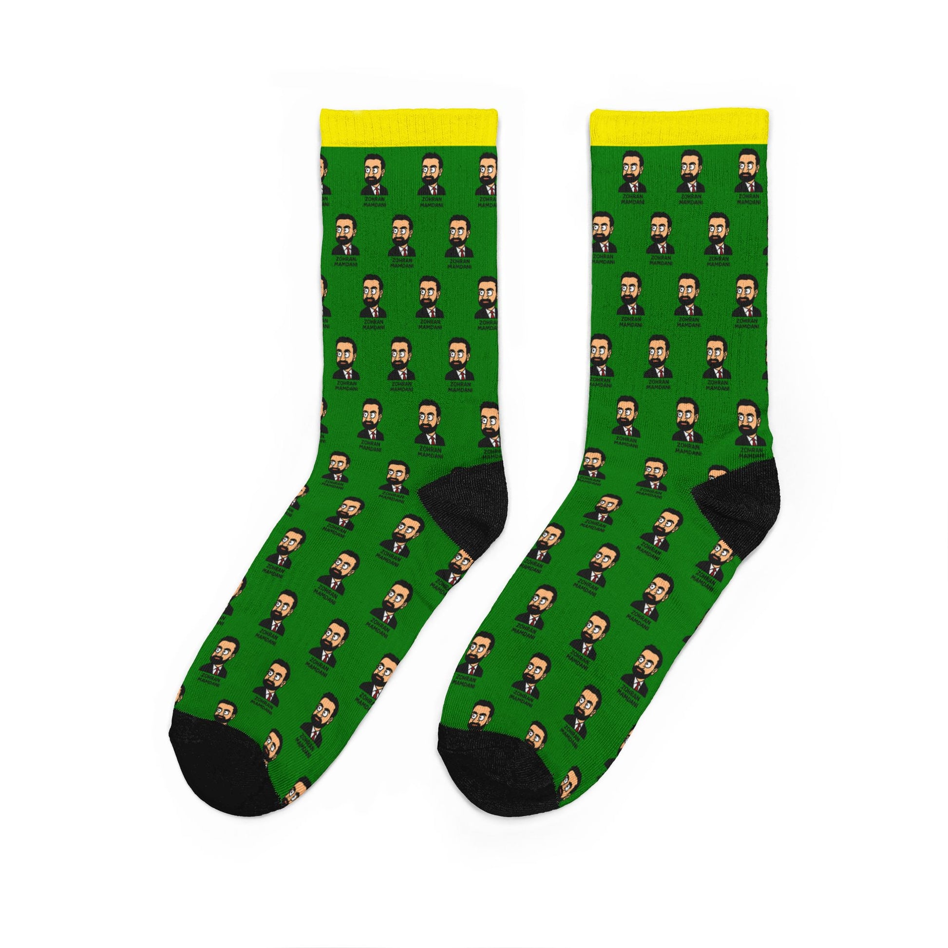 Zohran Mamdani novelty crew socks displayed at an angle highlighting the repeating portrait pattern, cushioned construction, and colorful political pop-art design.